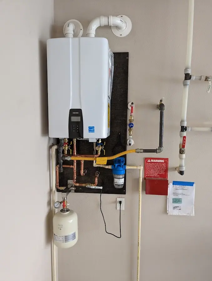 Professional plumber installing copper piping in a Port Vue home